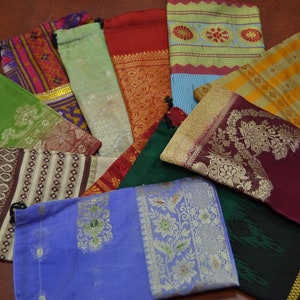May include: Assortment of colorful fabric pouches with various patterns and designs. The pouches are made of silk and have a drawstring closure.