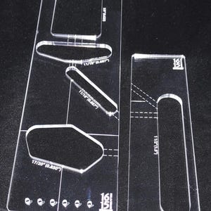 May include: A clear plastic template with various shapes and sizes marked with measurements in inches. The template is labeled "Body Cavity TEBC1" and includes measurements such as 11/16", 17/20", and 1 1/2".