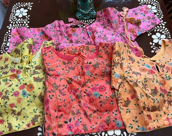 May include: Four floral patterned blouses in yellow, orange, and pink. The blouses have a round neckline and a tie at the back.