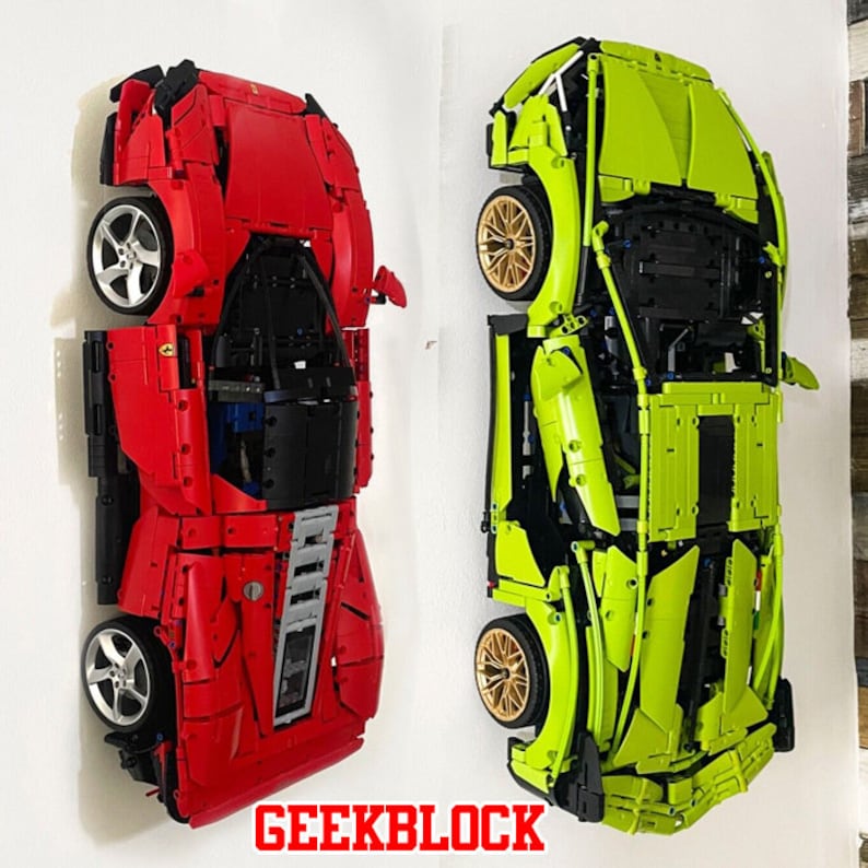 Może przedstawiać: Dwa modele samochod&oacute;w Lego, jeden czerwony, a drugi zielony, są wystawione na białej ścianie. Czerwony samoch&oacute;d to Ferrari, a zielony to Lamborghini. Samochody są zbudowane z klock&oacute;w Lego i są wystawione w rozmontowanym stanie, pokazując wewnętrzne działanie samochod&oacute;w.