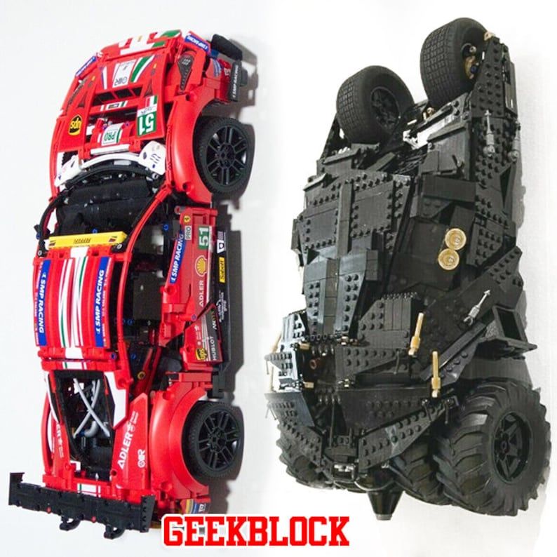 Może przedstawiać: Dwa modele samochod&oacute;w Lego, czerwony Ferrari i czarny Batmobil, są wyświetlane do g&oacute;ry nogami. Ferrari ma numer 51 na boku i napis "SMP RACING" na boku. Batmobil ma czarno-szary schemat kolorystyczny.