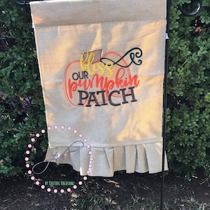 Może przedstawiać: Flaga ogrodowa z płótna jutowego z haftowaną dynią w kolorze brązowym, pomarańczowym i żółtym z tekstem "Bless Our Pumpkin Patch".