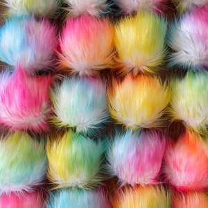 May include: A collection of colourful fluffy pom poms in shades of pink, blue, yellow, and green. The pom poms are arranged in rows and are all the same size.