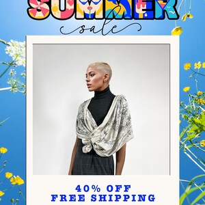 May include: A person wearing a dark gray turtleneck sweater and a light-colored scarf with a dark gray illustrative print. The image features the text SUMMER SALE at the top and 40% OFF FREE SHIPPING at the bottom, framed by yellow flowers.