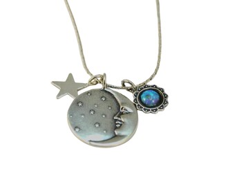 Puede incluir: Un collar de plata con un dije de luna creciente, un dije de estrella y un dije de ópalo azul.