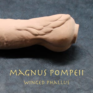 May include: A light brown, phallus-shaped sculpture with a detailed wing design. The text "MAGNUS POMPEII" and "WINGED PHALLUS" are printed in gold lettering on a dark blue background.