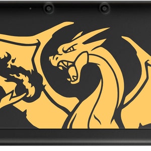 Puede incluir: Consola Nintendo 3DS XL negra con un diseño de dragón amarillo y negro en la tapa superior.