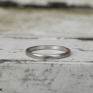 May include: A simple silver wedding band with a smooth, rounded surface.