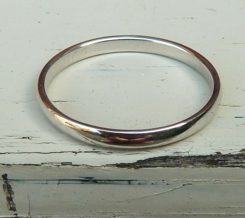 Puede incluir: Un anillo de banda de plata simple con un acabado liso y pulido.