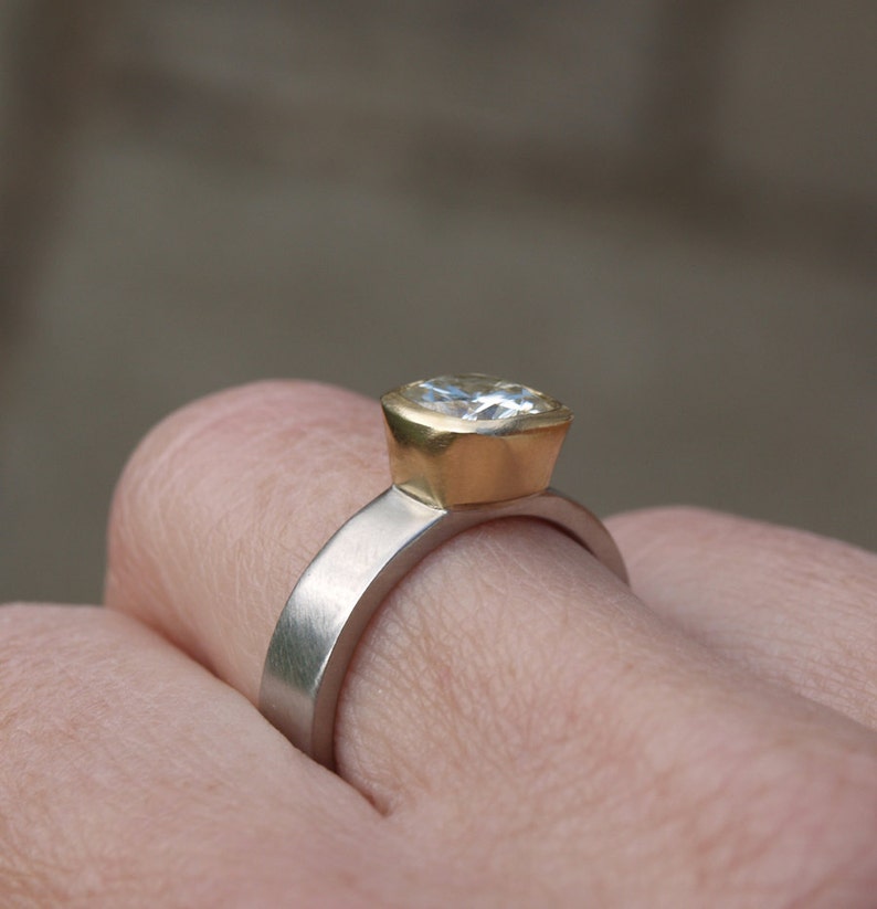 May include: A gold and silver ring with a large, clear, cushion-cut gemstone.
