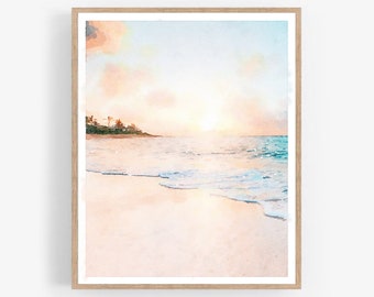 May include: Watercolor painting of a beach scene with a sunset. The artwork features a sandy beach, ocean waves, and a colorful sky with shades of pink, orange, and blue. The painting is framed in a light-colored wooden frame.