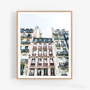 Puede incluir: Una pintura de acuarela de una fila de edificios parisinos con un edificio rosa en el centro. Los edificios tienen muchas ventanas y balcones. El cielo es azul claro con nubes blancas.
