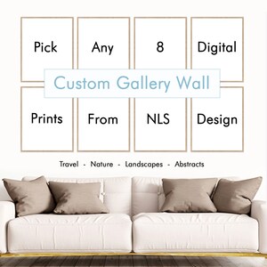 May include: A white couch with brown throw pillows sits in front of a wall with a custom gallery wall design. The wall features eight framed prints with the words "Pick", "Any", "8", "Digital", "Prints", "From", "NLS", and "Design". The text "Custom Gallery Wall" is written in a light blue box on the wall. The text "Travel - Nature - Landscapes - Abstracts" is written below the gallery wall.