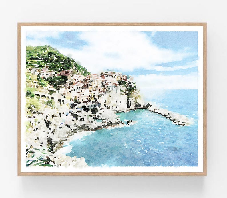 K&ouml;nnte beinhalten: Ein Aquarellbild einer K&uuml;stenstadt, die in eine Klippe gebaut ist. Die Stadt ist in Rosa-, Gelb- und Wei&szlig;t&ouml;nen gemalt, mit einem blauen Meer im Vordergrund. Der Himmel ist hellblau mit wei&szlig;en Wolken.