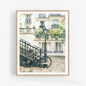 Puede incluir: Una pintura de acuarela de una escena de calle parisina con una bicicleta negra estacionada frente a un edificio blanco con plantas verdes y una farola.