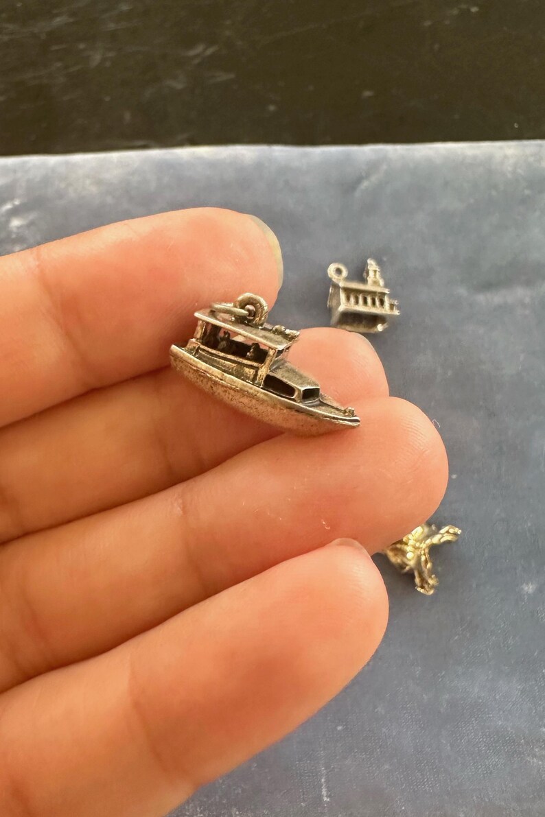Peut inclure: Charme en argent d'un petit bateau avec une cabine, un charme populaire pour la fabrication de bijoux.