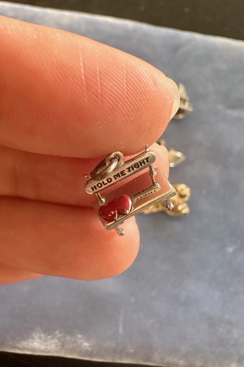 Peut inclure: Charme en argent avec deux c&oelig;urs rouges sur une petite table avec l'inscription "Hold Me Tight" grav&eacute;e sur le c&ocirc;t&eacute;.
