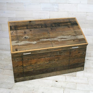 Puede incluir: Un cofre de almacenamiento de madera r&uacute;stico con una tapa con bisagras y cierres met&aacute;licos. El cofre est&aacute; hecho de madera recuperada con un acabado natural.