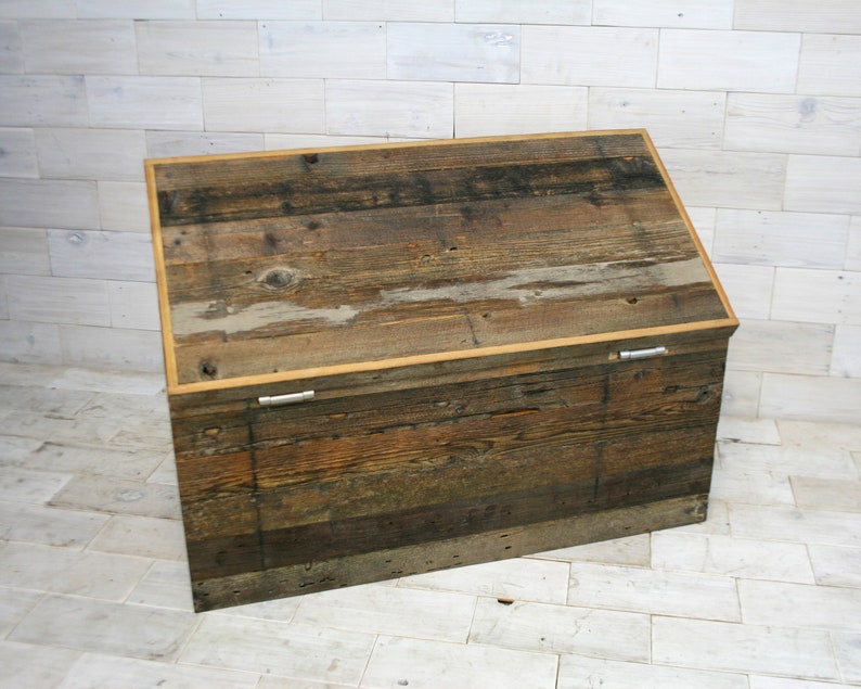 Puede incluir: Un cofre de almacenamiento de madera r&uacute;stico con una tapa con bisagras y cierres met&aacute;licos. El cofre est&aacute; hecho de madera recuperada con un acabado natural.