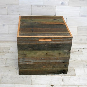 Puede incluir: Una caja de almacenamiento de madera con un aspecto r&uacute;stico y desgastado. La caja est&aacute; hecha de madera recuperada con un acabado natural y tiene una tapa con bisagras. La caja mide aproximadamente 46 cm de ancho, 30 cm de profundidad y 30 cm de alto.