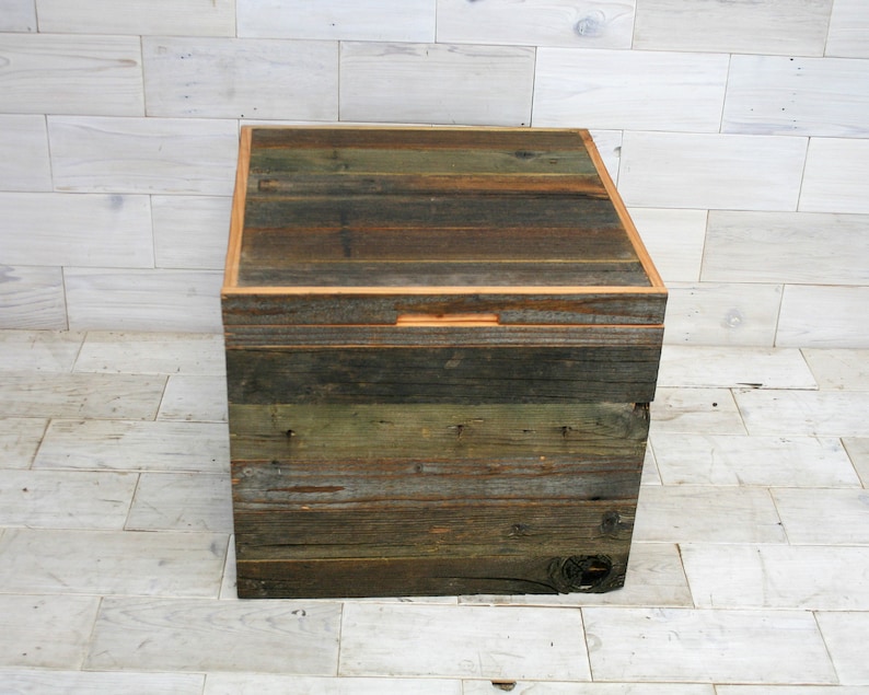 Puede incluir: Una caja de almacenamiento de madera con un aspecto r&uacute;stico y desgastado. La caja est&aacute; hecha de madera recuperada con un acabado natural y tiene una tapa con bisagras. La caja mide aproximadamente 46 cm de ancho, 30 cm de profundidad y 30 cm de alto.
