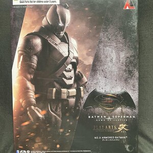 May include: A rectangular product box featuring an armored Batman action figure. The packaging displays the text Batman v Superman: Dawn of Justice, Play Arts Kai, and No.3 Armored Batman. The design includes a warning label for choking hazards.