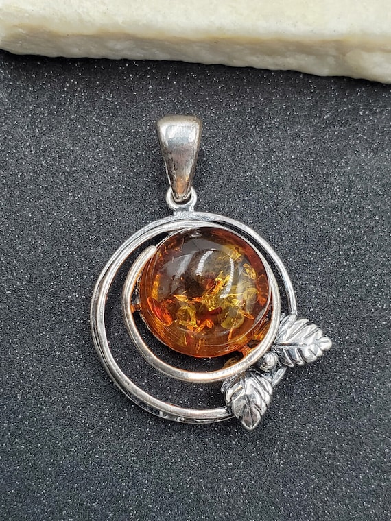 Honey Amber Circle w/Accented Sterling Silver Design on Bale Honey Amber Circle w/Accented Sterling Silver Design on Bale