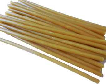 May include: A bundle of approximately 20 thin, golden yellow, drinking straws made of a natural material like paper or bamboo.