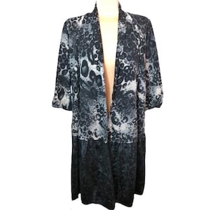 May include: A long, open-front duster in a black, gray, and white animal print. The duster has three-quarter sleeves and a tiered skirt. The fabric appears to be lightweight, suitable for layering. The overall style is casual and bohemian.