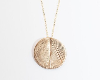 A sterling silver or gold vermeil peacock feather imprint necklace