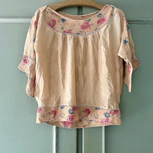 Genuine vintage 1920s champagne semi sheer silk blouse with delicate floral border and fluttery sleeves. Best fits size xs.