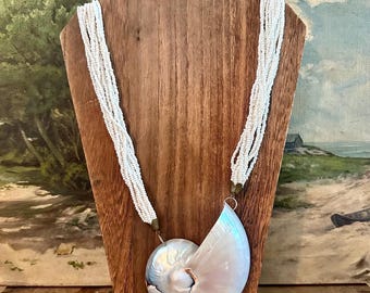 Vintage monumental pearlized chambered spiral nautilus shell pendant on 1940s 12-strand white shell bead necklace. Stunning one-of-a-kind