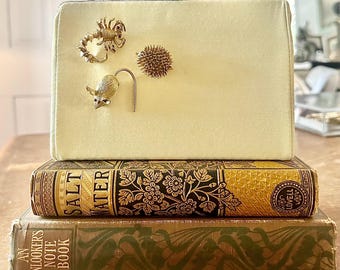 1950s butter yellow purse adorned with vintage mouse, scorpion, hedgehog brooches with faux ruby eyes, one-of-a-kind archival custom piece