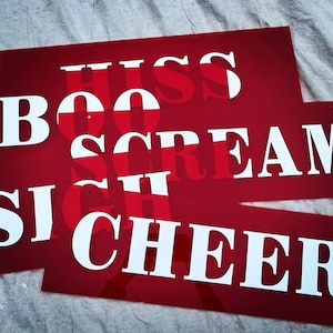 May include: Red rectangular signs with white text. The signs display words like "BOO", "HISS", "SIGH", "SCREAM", and "CHEER". The text is in a bold, sans-serif font.