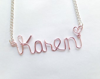 May include: A silver chain necklace with a pink wire name pendant that says "Karen" and a heart charm.