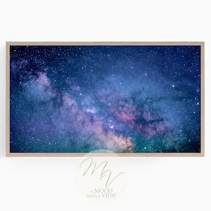 Puede incluir: Una impresión enmarcada de un cielo nocturno con una nebulosa vibrante de color púrpura y azul, llena de estrellas. La imagen es un primer plano de la Vía Láctea.