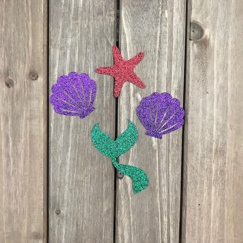 May include: A set of four glitter-covered paper cutouts: a red starfish, two purple seashells, and a green mermaid tail.