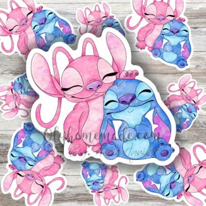May include: Watercolour sticker featuring a pink and blue Stitch and Angel couple. The characters are hugging and have their eyes closed. The sticker is on a white background.
