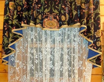 May include: A window with a floral patterned valance and sheer white lace curtains. The valance has a blue and gold trim.