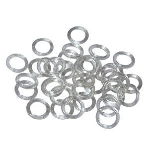 May include: A pile of clear rubber bands, also known as hair ties, in various sizes.