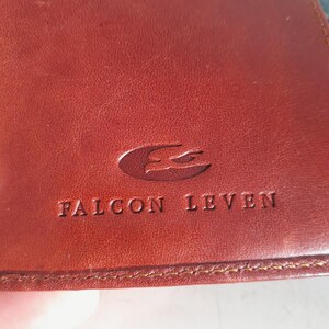 May include: A white ceramic mug with a black handle and the text "But First, Coffee" in a black, bold font. The mug is sitting on a wooden surface.