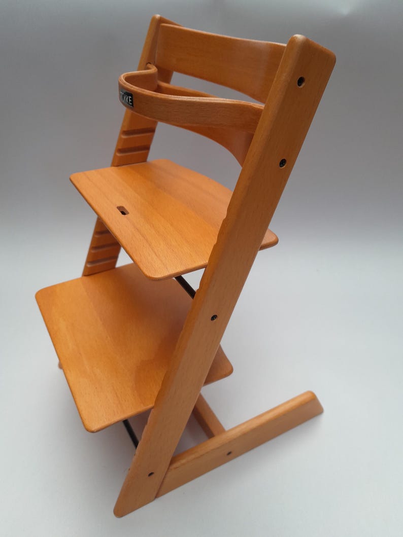 Puede incluir: Silla alta de madera con acabado natural. Cuenta con respaldo curvo, dos niveles de asiento ajustables y reposapi&eacute;s. El dise&ntilde;o es sencillo y funcional, centrado en la seguridad y comodidad del ni&ntilde;o. Fabricada en madera maciza.