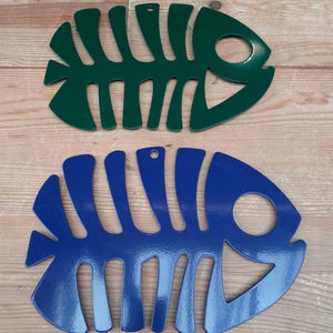Op de afbeelding: Twee metalen visvormige wanddecoraties. De bovenste vis is groen en de onderste vis is blauw.