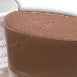 May include: A white ceramic mug with a black handle and the text "But First, Coffee" in a bold, black font. The mug is set against a neutral background, highlighting its simple design.