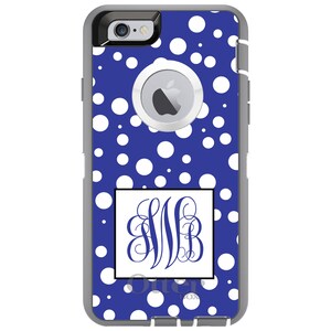 May include: A blue and white polka dot phone case with a monogrammed initial "MB" in a white square with a black border. The case is made for an iPhone and has a gray OtterBox logo.