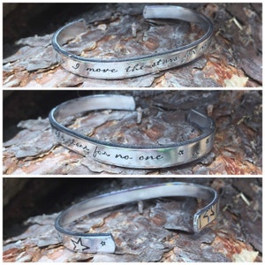 Peut inclure: Bracelet en argent avec l'inscription "Je déplace les étoiles pour personne" et des accents d'étoiles.