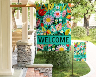 May include: A vibrant teal welcome flag with a floral design featuring daisies, red tulips, and yellow leaves. The word "WELCOME" is displayed in large white letters on a teal banner. A smaller matching flag is also visible.