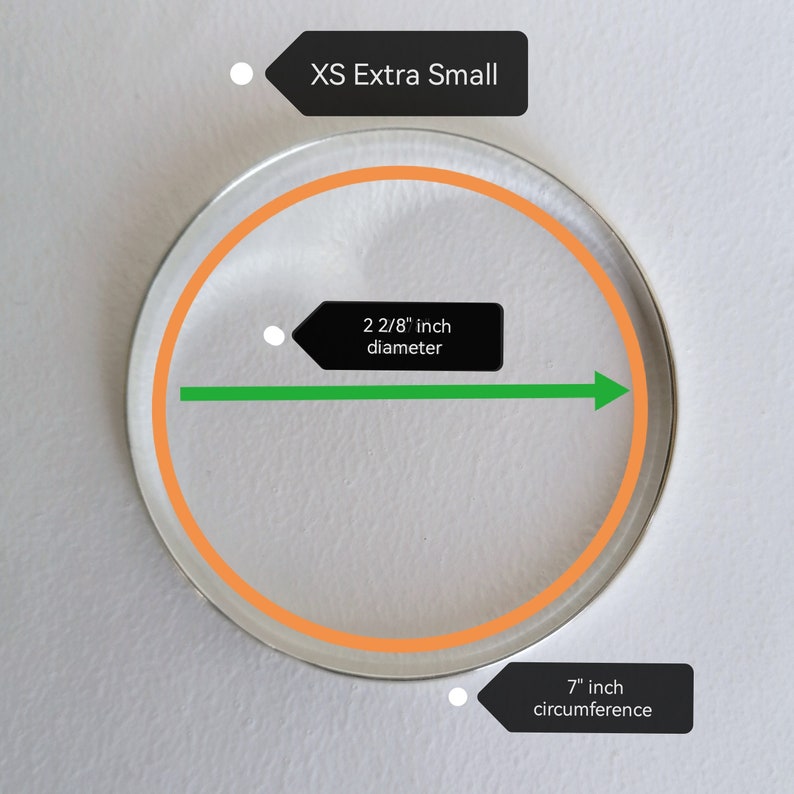 May include: A white circle with an orange outline, measuring 2 2/8 inches in diameter and 7 inches in circumference. The text "XS Extra Small" is written in black on a white background.