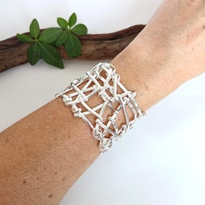 Pulsera llamativa tejida a mano, brazalete ancho de plata, diseño abstracto, pieza única, bañada en plata.