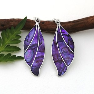 Peut inclure: Une paire de boucles d'oreilles en argent avec des pendentifs en forme de feuille en nacre d'ormeau violette.